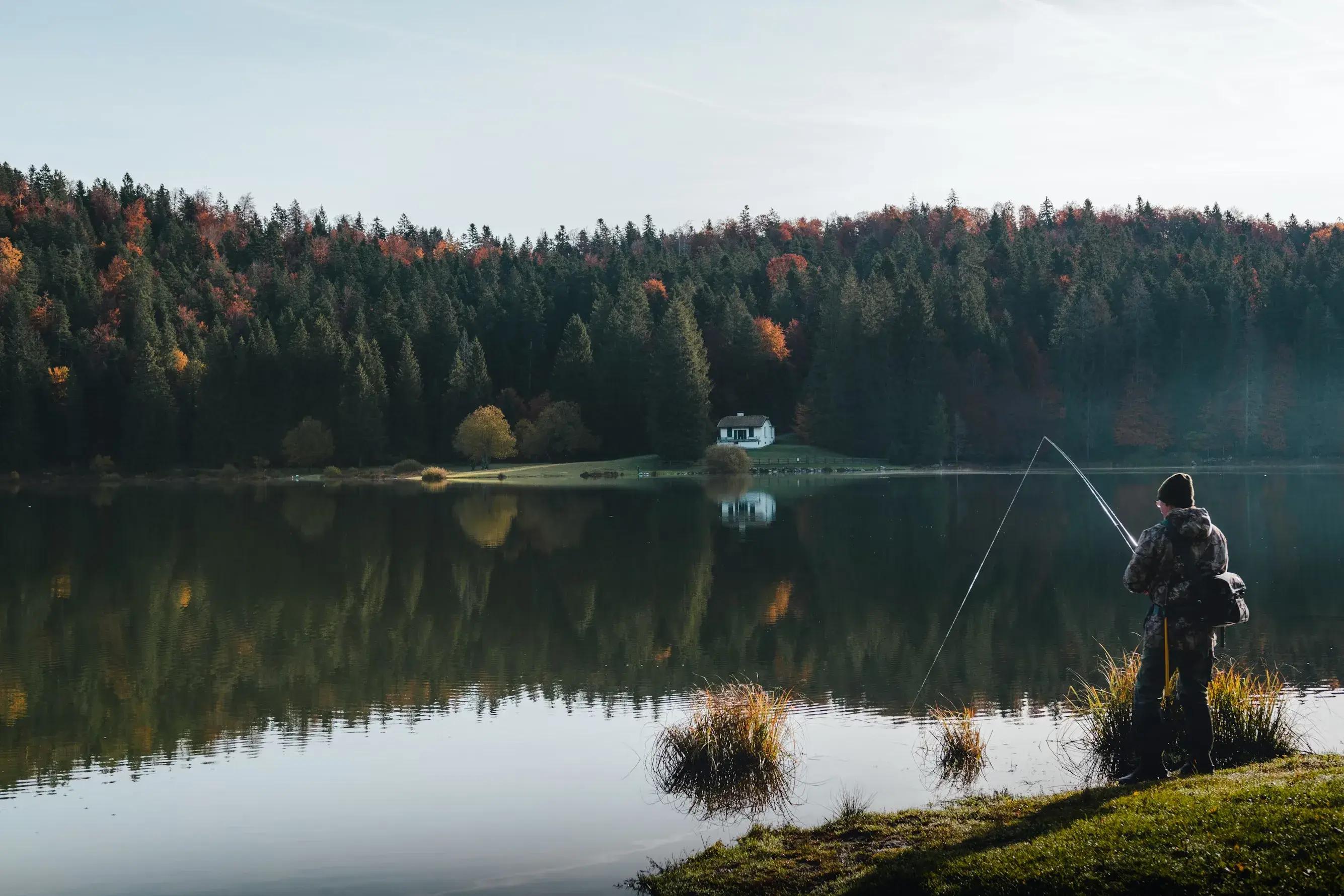Person fishing by a lake